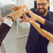 Equipo de trabajo motivado y unido celebrando logros con energía positiva, reflejando el poder de la colaboración y un ambiente laboral saludable.